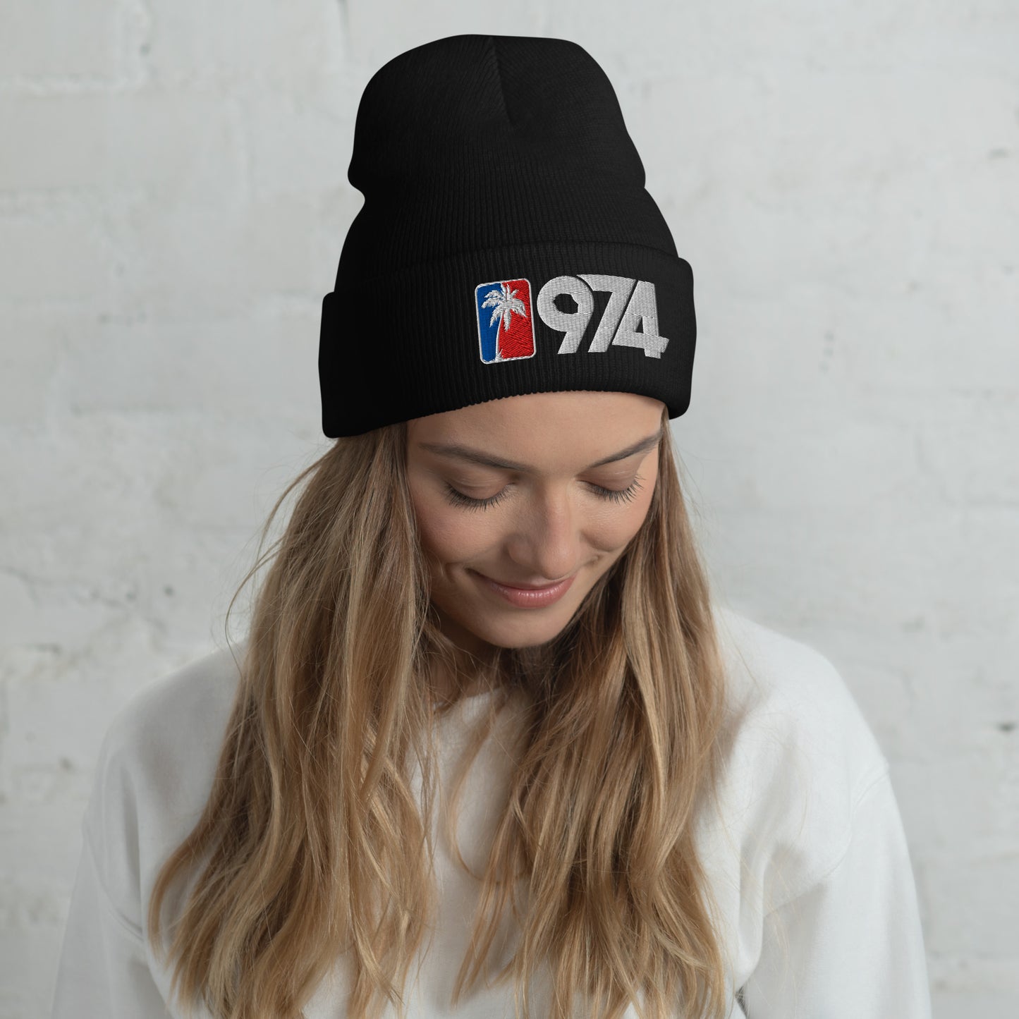 Femme portant un bonnet 974 Ile de la Réunion avec palmier blanc sur fond rouge et bleu, design streetwear péï.